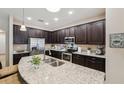 Modern kitchen with stainless steel appliances, granite countertops, and dark wood cabinetry at 9917 Prevatt St, Gibsonton, FL 33534