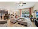 Open-concept living room with tile floors, ceiling fan, and sliding glass doors leading to the patio at 9917 Prevatt St, Gibsonton, FL 33534