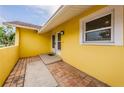 Exterior brick lined entrance to home with white trim window and doorway at 10051 82Nd Ln, Seminole, FL 33777