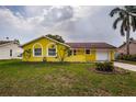 Charming yellow single-story home featuring a one-car garage and well-maintained front yard at 10051 82Nd Ln, Seminole, FL 33777
