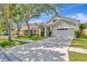 Exterior view of home with well-manicured lawn, attractive landscaping, and a two-car garage at 10819 Newbridge Dr, Riverview, FL 33579