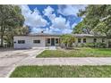 Inviting single-story home boasts a freshly painted white brick exterior and tidy front yard landscaping at 1145 53Rd N Ave, St Petersburg, FL 33703