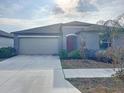 Inviting home with a two-car garage, red front door, and well-kept landscaping at 11524 Sage Canyon Dr, Riverview, FL 33578