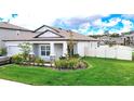 Beautifully landscaped single-Gathering home with a fenced yard and a well-maintained lawn at 12687 Retreat Pl, Spring Hill, FL 34610
