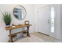 Bright foyer featuring a modern console table with a decorative mirror and a stylish rug at 12687 Retreat Pl, Spring Hill, FL 34610