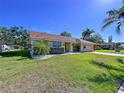 Lovely single-story home with a well-maintained lawn and mature landscaping at 1599 Mcauliffe Ln, Palm Harbor, FL 34683