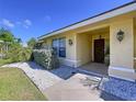 Close up of a charming front porch with decorative lights and a beautiful wooden door at 1599 Mcauliffe Ln, Palm Harbor, FL 34683