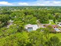 Aerial view of a home nestled within a lush, green neighborhood with mature trees at 1675 Robin Hood Ln, Clearwater, FL 33764