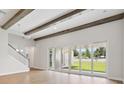 An open-concept living room with wooden beams, and sliding glass doors that lead to the backyard at 174 Hidden Estates Ct, Brandon, FL 33511