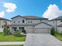 Inviting two-story home with a three-car garage and lush green lawn at 17845 Cortes Creek Blvd, Spring Hill, FL 34610