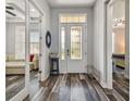 Inviting foyer with decorative glass front door, gorgeous wood-look flooring, and modern accents at 17914 Bramshot Pl, Lutz, FL 33559