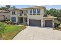 Beautiful two-story home showcasing a three-car garage, manicured lawn, and a charming balcony at 17914 Bramshot Pl, Lutz, FL 33559
