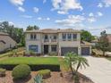Attractive two-story home features a three-car garage, neat lawn, and elegant blue shutters at 17914 Bramshot Pl, Lutz, FL 33559