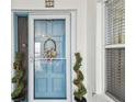 Charming front door with a wreath and decorative plants adds curb appeal to this inviting home at 17980 Gulf Blvd # 505, Redington Shores, FL 33708