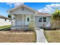 Charming single-story home with a cozy front porch and a beautifully landscaped front yard at 2107 W Carmen St, Tampa, FL 33606