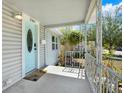 Welcoming front porch featuring a decorative railing and a freshly painted light blue front door at 2107 W Carmen St, Tampa, FL 33606