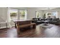 Spacious living room featuring dark wood floors, a leather sofa set, and abundant natural light from the windows at 2107 W Carmen St, Tampa, FL 33606