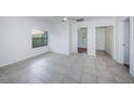 Spacious living room with tile flooring, neutral paint, ceiling fan, and natural light at 2443 2Nd S Ave, St Petersburg, FL 33712