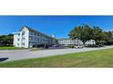 Exterior view of the multi-story condo building with well-maintained landscaping and ample parking at 2468 Florentine Way # 26, Clearwater, FL 33763