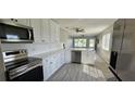 Modern kitchen with stainless steel appliances, white cabinets, and a bright dining area at 2468 Florentine Way # 26, Clearwater, FL 33763