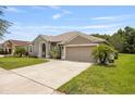 Attractive home with well-kept lawn, a large driveway and two car garage in a suburban setting at 25942 Risen Star Dr, Wesley Chapel, FL 33544