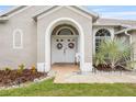 Inviting front entrance with double doors, decorative wreaths, and charming landscaping at 25942 Risen Star Dr, Wesley Chapel, FL 33544