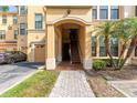 Condo building entrance with a paved walkway, palm trees, and attached garage at 2739 Via Capri # 1011, Clearwater, FL 33764