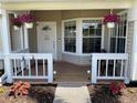 Cozy front porch decorated with hanging floral baskets, seating, and a welcoming front door at 2861 Penridge Dr, Palm Harbor, FL 34684