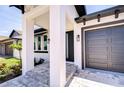 Covered porch entrance to a contemporary home with stone steps and modern black door at 3004 W Abdella St, Tampa, FL 33607