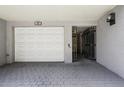 View of a gray-tone carport with white garage doors, an entry gate, and brick pavers at 301 2Nd N St # 15, St Petersburg, FL 33701
