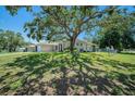 Attractive single-story home with attached garage beneath a mature shade tree at 3305 Blythe Ave, Spring Hill, FL 34609