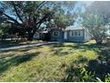 Inviting single-story home featuring a simple, landscaped front yard with mature trees and a walkway at 4214 Fairfield S Ave, St Petersburg, FL 33711