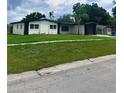 Landscaped front yard showcasing a charming single-story home with a well-maintained lawn at 4434 Bass St, Tampa, FL 33617