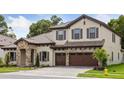 Charming two-story home with stone accents, a tile roof, a three-car garage, and manicured landscaping at 4523 Foley Grove Dr, Valrico, FL 33596