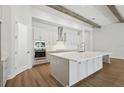 Bright, white kitchen with stainless steel appliances, granite countertops, and wooden beams at 4523 Foley Grove Dr, Valrico, FL 33596