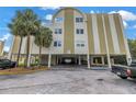 Exterior of a condo building with covered parking and palm trees in a tropical setting at 4651 1St Ne St # 402, St Petersburg, FL 33703