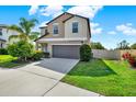 Charming two-story home featuring a two-car garage, landscaped yard, and fenced area at 5067 Sable Chime Dr, Wimauma, FL 33598