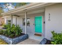 Close-up of a charming turquoise front door with a welcoming 'welcome' mat at 526 62Nd Ne Ave, St Petersburg, FL 33702