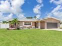 Charming one-story home with a well-manicured lawn, gray roof, neutral paint, and attached garage at 5470 Bayshore Dr, Seminole, FL 33772