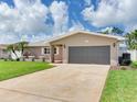 Inviting one-story home with a gray garage door, neutral paint, and a meticulously maintained lawn at 5470 Bayshore Dr, Seminole, FL 33772