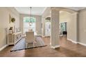 Elegant dining room with hardwood floors, decorative columns, and a view of the foyer and entryway at 5825 Terncrest Dr, Lithia, FL 33547