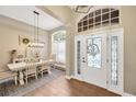 Bright foyer with decorative front door, wood floors, and dining area with stylish light fixture and window shutters at 5825 Terncrest Dr, Lithia, FL 33547