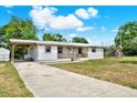 Side view of a charming one-story home with a covered carport, porch, and a well-maintained lawn at 6020 N 50Th St, Tampa, FL 33610