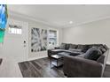 Bright living room features wood flooring, a large gray sectional sofa, and a picture window at 6020 N 50Th St, Tampa, FL 33610
