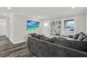 Inviting living room with gray sectional, TV, wood floors, and decor that creates a cozy atmosphere at 6020 N 50Th St, Tampa, FL 33610