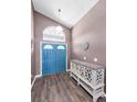 Inviting foyer featuring a blue double door entrance, wood floors and a stylish console table at 6521 Oelsner St, New Port Richey, FL 34652
