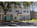 Inviting townhome with a well-manicured lawn, reserved parking, and pretty pastel-colored doors and shutters at 8545 Hunters Key Cir, Tampa, FL 33647