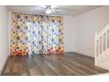 A brightly lit living room with sleek hardwood floors, ceiling fan and an adjacent staircase at 8545 Hunters Key Cir, Tampa, FL 33647