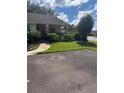 Landscaped front yard with mature bushes, green grass, and a view of the villa at 9302 Trowbridge Ct, New Port Richey, FL 34655