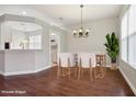 Bright dining room showcasing wood floors, natural light and modern chandelier, virtually staged with modern furniture at 9329 Huntington Park Way, Tampa, FL 33647